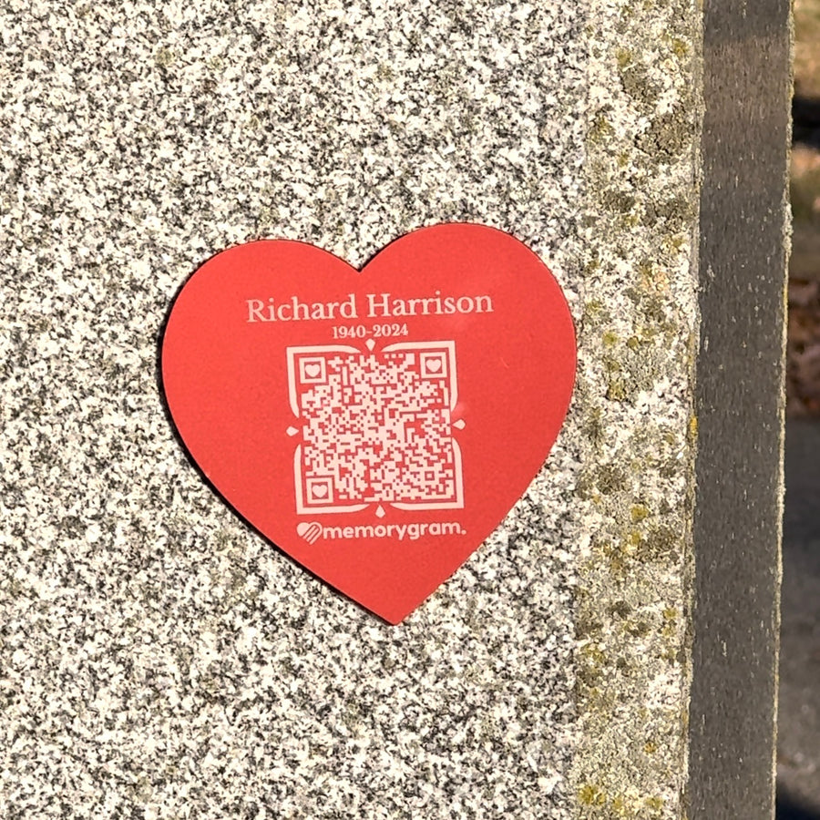 Red heart Memorygram QR medallion engraved with a name and years of life, on a granite headstone