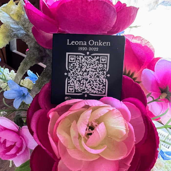 Black square Memorygram medallion engraved Leona Onken, among pink flowers