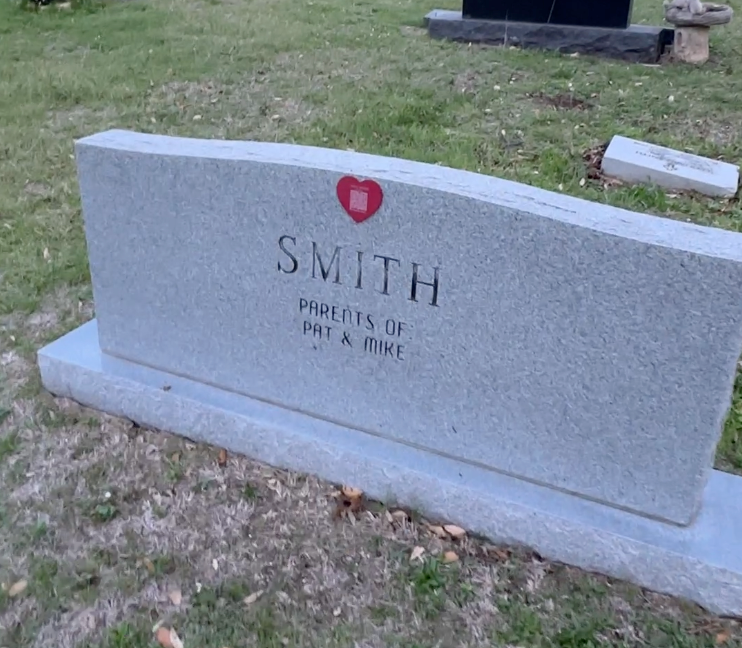 A red heart Memorygram medallion on a granite family headstone