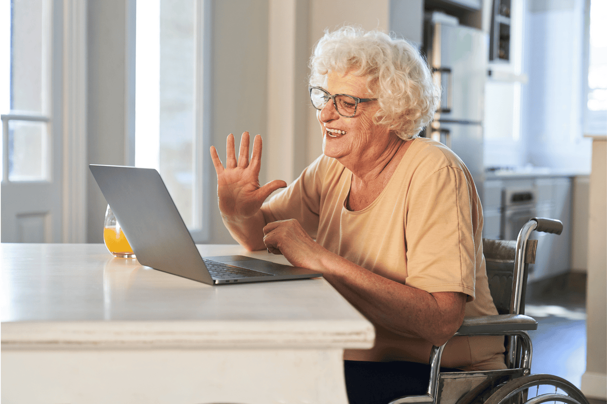 An older woman smiling during a relaxed remote biography interview from home
