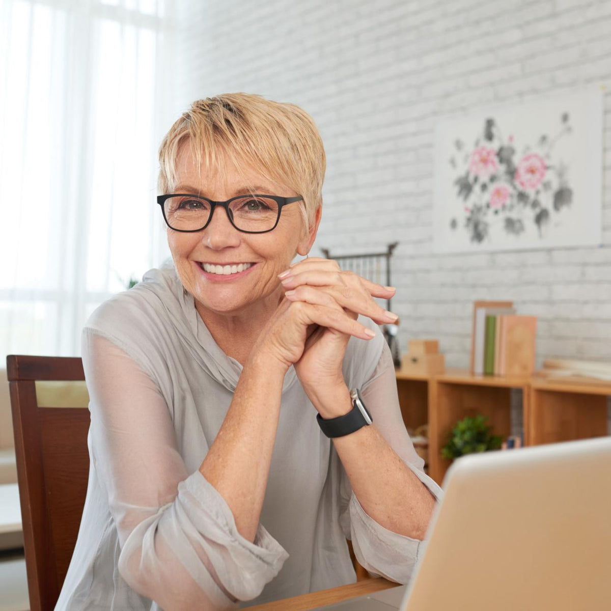 A woman smiling during a relaxed remote biography interview from home