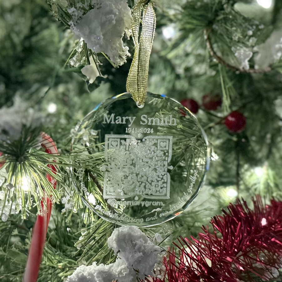 Memorial QR Ornament with engraved saying hanging on a Christmas tree