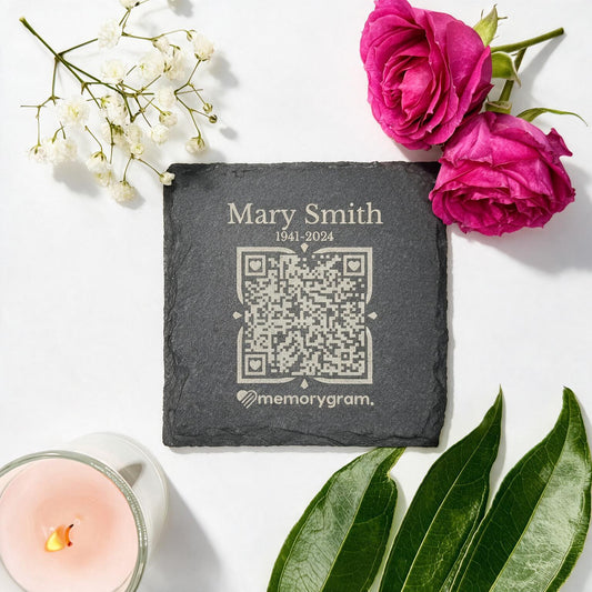 Memorial QR slate coaster engraved with name, dates and QR code, styled with flowers and candle