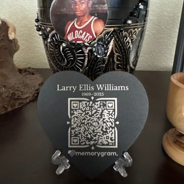 Customer photo: black heart Memorygram medallion engraved Larry Ellis Williams, on its stand beside an urn