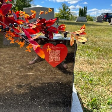 Customer photo: red heart Memorygram medallion on a headstone among autumn leaves